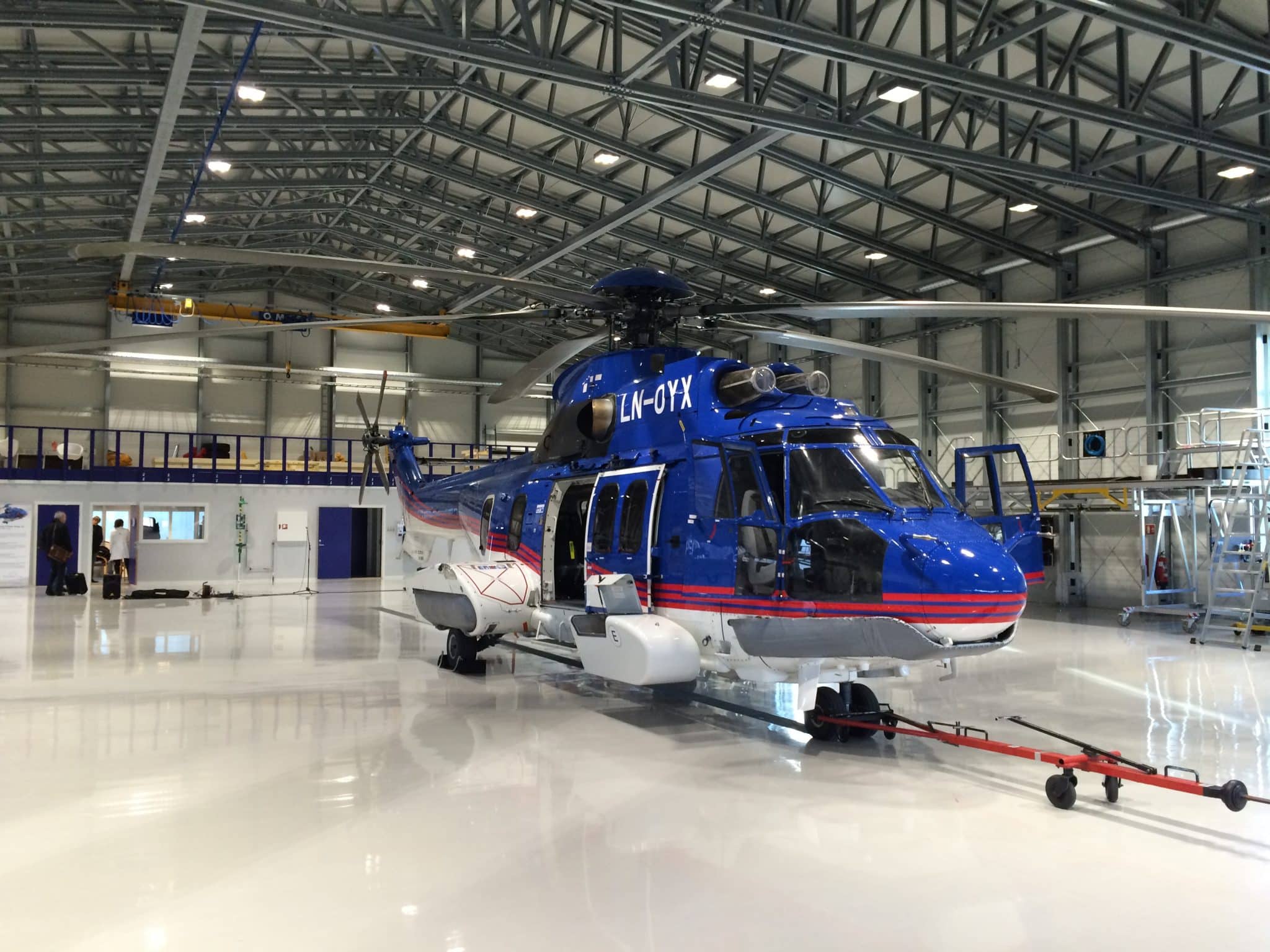 Photo d'un bâtiment aéronautique abritant un hélicoptère bleu