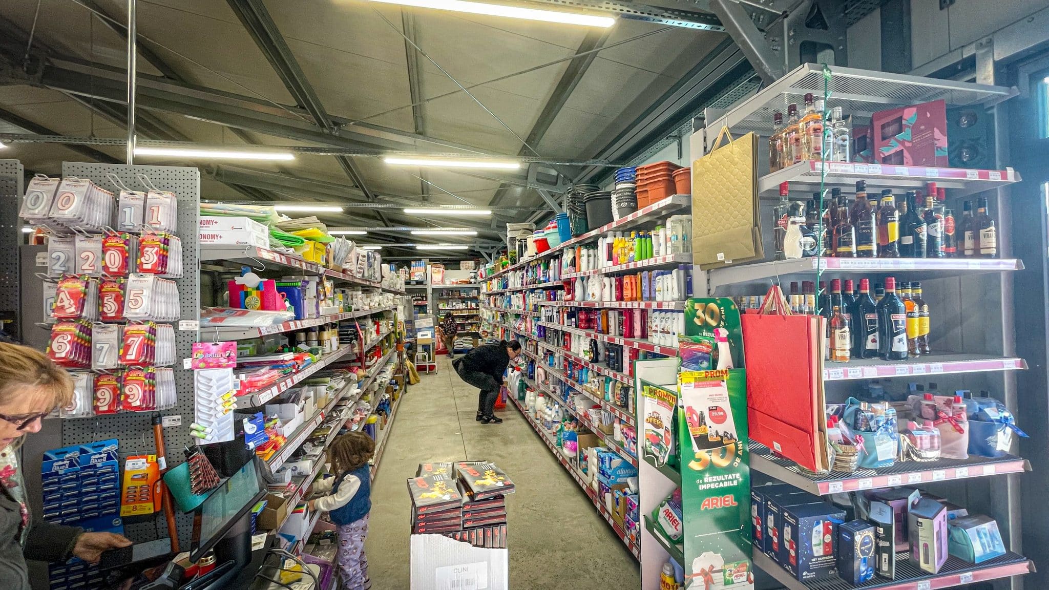 Rafturi comerciale și zonă de vânzare în supermarketul amenajat în hala metalică Frisomat