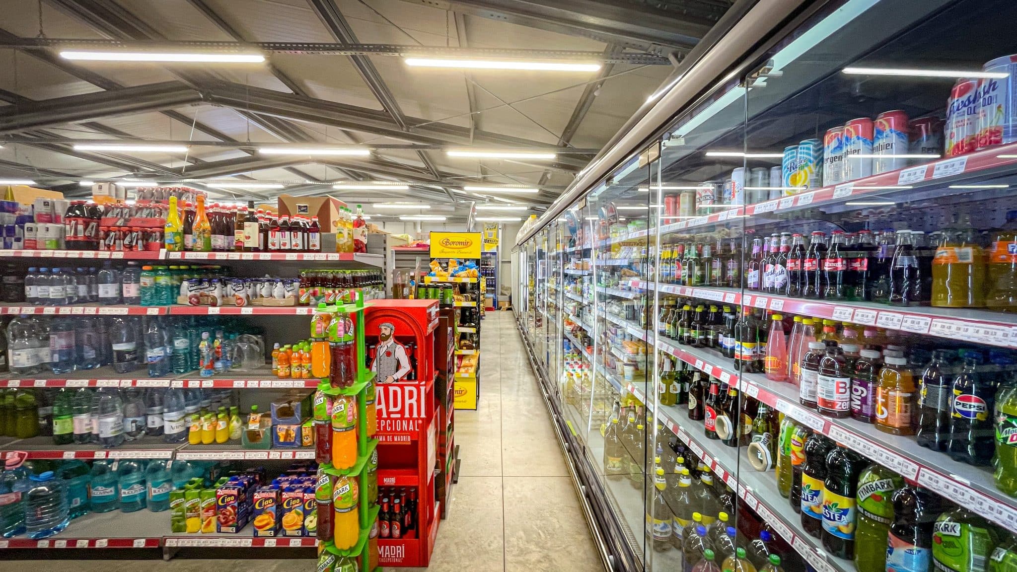 Culoar comercial și vitrine frigorifice în supermarketul construit într-o hală metalică Frisomat